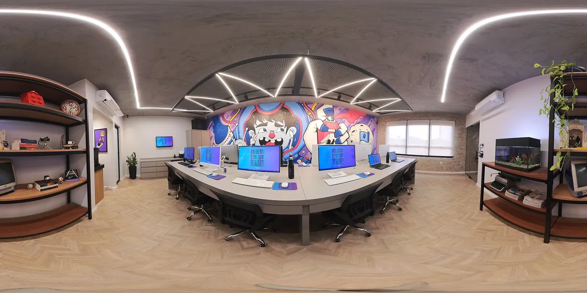 A sala de criação da Moinho vista de cima, com o mural grafitado, as estações de trabalho e as estantes
