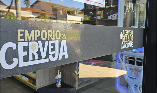 Adesivo interno do Empório da Cerveja sobre o vidro da loja, com o nome da marca