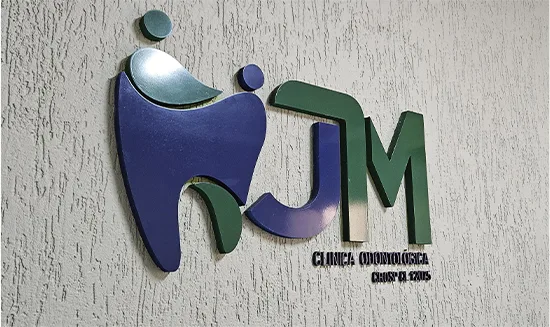 Símbolo da JM Clínica Odontológica em PVC expandido, aplicado na parede de recepção