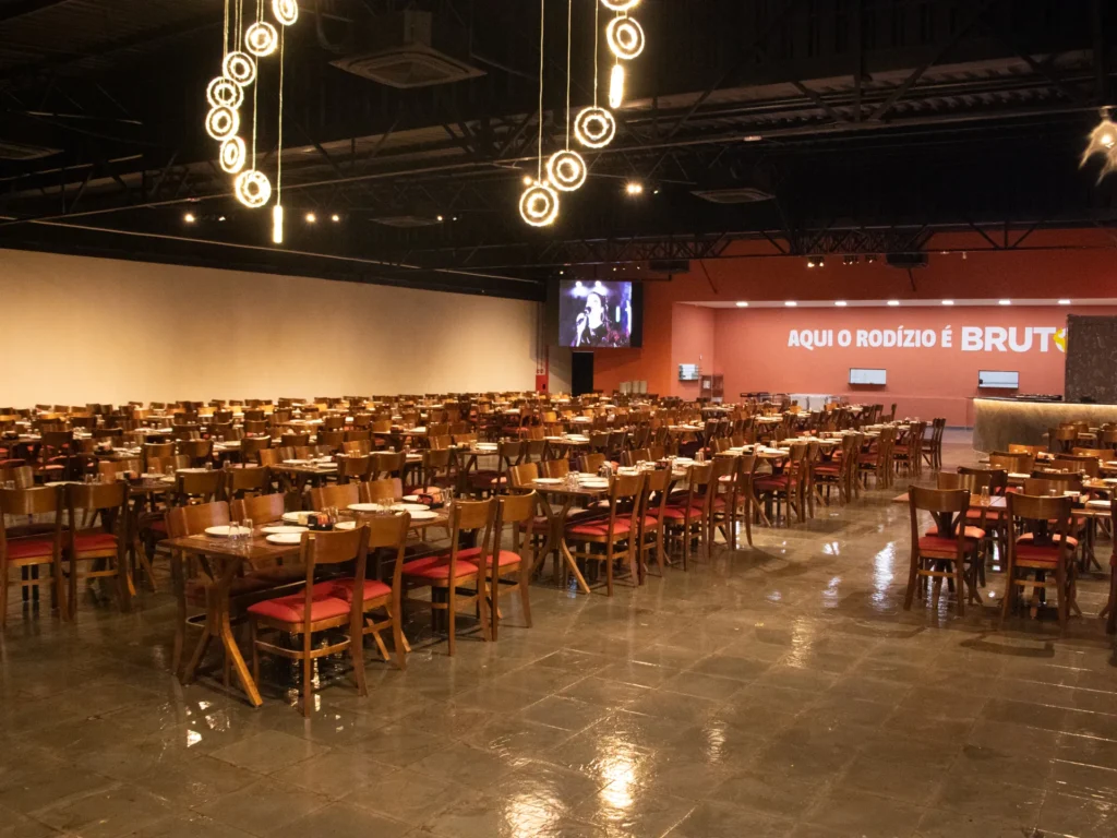 Salão amplo do Ponto da Pizza Rio Claro com luminárias pendentes e mesas postas